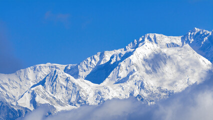 Crisp view of Kanchenjunga from Phalut, India. Himalayan mountain range, blue sky, and pristine snow—ideal for trekking, travel photography, and high-altitude nature visuals
