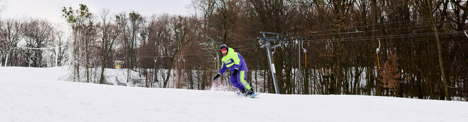 Bearded man enjoys snowboarding on a snowy slope during winter fun