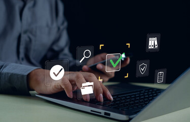 Man using smartphone and laptop with digital icons of check marks, folders, and shield security symbols. Concept of online verification, data protection, cybersecurity, digital authentication system.