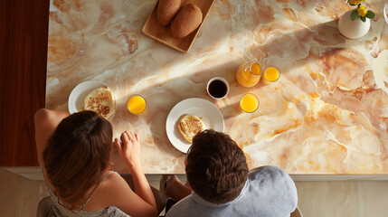 Couple making breakfast at island, overhead composition bright natural light, marble countertop texture, warm tones.