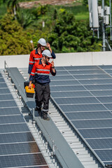 Solar engineer teamwork on rooftop maintenance checks deliver clean energy under bright sun with safety gear and focused coordination