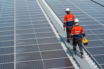 Solar engineer teamwork on rooftop maintenance ensures energy flow under bright daylight as two workers walk along panel rows with tool box and focus on safety and inspection