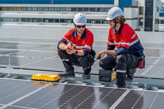 Solar engineer teamwork maintenance energy rooftop solar panel installation as two male technicians helmet perform inspection and repair with tool daylight showing professional focus and safety - Powered by Adobe