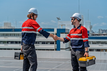 Solar engineer teamwork maintenance energy handshake rooftop after successful panel service bright sky showing professional collaboration and safety gear during routine inspection with positive