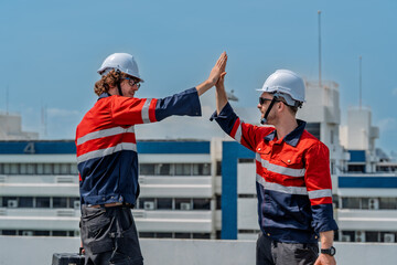 Solar engineer teamwork maintenance energy success on rooftop after repair with protective gear under bright sky