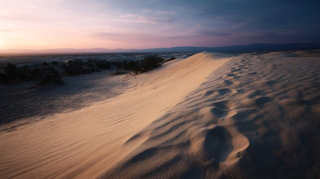 Vast desert landscape at twilight with rippling sand dunes showcasing footprints under a soft colorful gradient sky - Powered by Adobe
