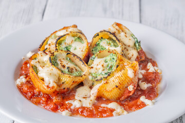 Plated lumaconi stuffed with ricotta and spinach topped with fresh tomato sauce