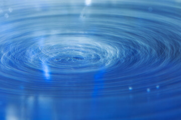 Long exposure shot of a water surface showing a whirlpool. Macro shot showing white concentric circles.