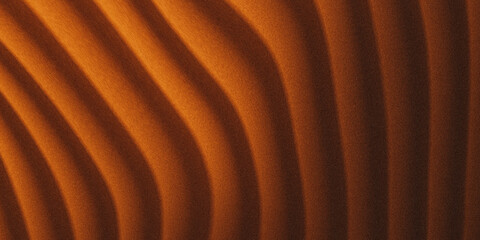 Abstract close-up of warm undulating sand dunes under dramatic lighting creating a textured pattern