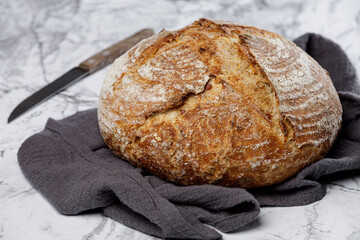 Traditional wheat rustic sourdough bread on a marble background