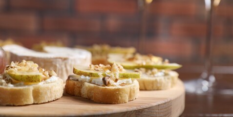 Delicious bruschettas served with camembert on wooden table, closeup
