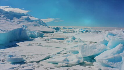 massive blue ice blocks and frozen sea, cracks forming on the surface, clear blue sky above, dramatic arctic landscape, symbol of climate change and global warming, cold and majestic atmosphere - Powered by Adobe