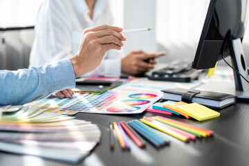 Two creative graphic designer team working on color selection and drawing on graphic tablet, Color swatch samples chart for selection coloring in inspiration to creativity at workplace