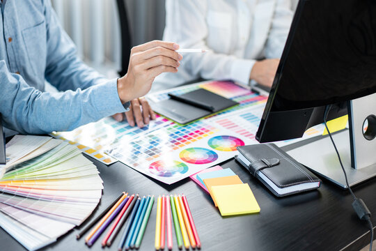 Team of creative graphic designer working on color swatch samples chart for selection coloring in inspiration to create new collection at workplace