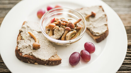 Delicious mushroom pâté served on toasted bread with grapes for a delightful snack