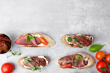 Delicious bruschettas with roast beef served on light table, flat lay. Space for text