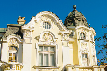 Fototapeta premium Elegant historic building with ornate architectural facade and domed roof under clear blue sky