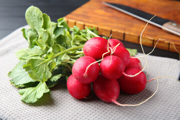 Fresh ripe radishes on black table, closeup