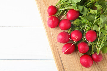 Fresh ripe radishes on white wooden table, top view. Space for text
