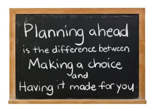 Planning ahead saying handwritten in white chalk on a black chalkboard isolated in a wooden frame