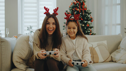 Family bonding time during the holidays while playing video games in a cozy living room decorated for Christmas