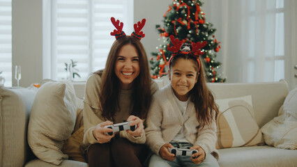 Family enjoys video games together during Christmas holiday season with festive decorations in a cozy living room
