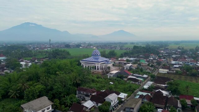 Aerial view of a beautiful mosque with Mount Kawi and Mount Arjuno in the background, Malang Regency, Indonesia