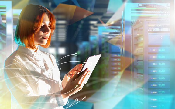 IT specialist monitors data servers using digital tablet in modern data center. Information technology, cloud computing and network administration.