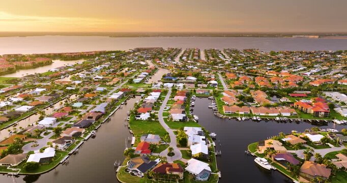 Evening skyline of premium waterfront community in Florida. Expensive homes and mansions under sundown light.