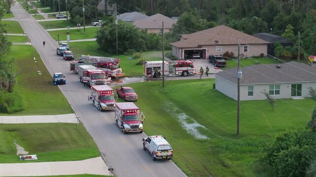 First responders arrived at fire alarm call ready to extinguish fire of burning house. Emergency service personnel responding to potential fire hazard at Florida home.