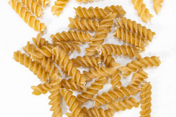 Spiral Brown Pasta on White Background, Close-Up Dry Pasta