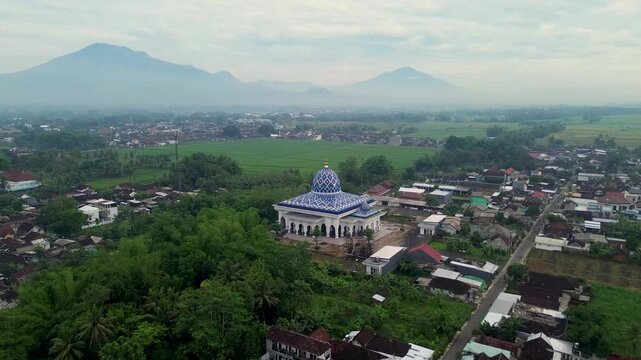 Aerial view of a beautiful mosque with Mount Kawi and Mount Arjuno in the background, Malang Regency, Indonesia