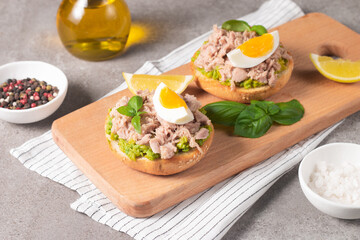 Two delicious tuna open sandwiches with avocado and boiled eggs. Tuna toast.