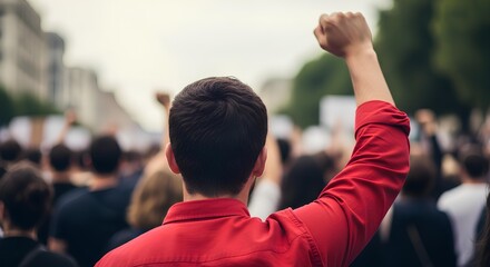 A person raises their fist in the air at a protest, symbolizing activism and social change