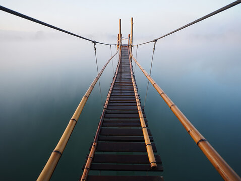 Bamboo suspension bridge over misty water bamboo bridge - Powered by Adobe
