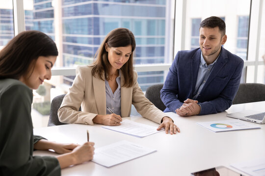 Fototapeta Female business partners signing contract on meeting, sitting at table