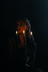A mysterious woman stands in silhouette against a bright window, surrounded by dramatic smoke and shadows