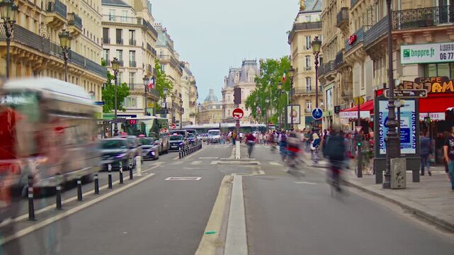 France, Paris, 25.08.2025: French street Rivoli in centre Paris with cars, people and cyclists. City traffic in the city center. Timelapse