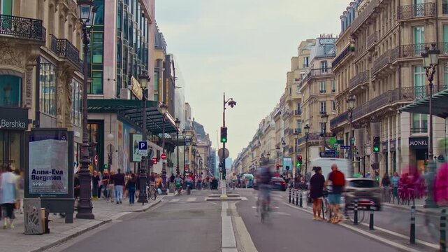 France, Paris, 25.08.2025: French street Rivoli in centre Paris with cars, people and cyclists. City traffic in the city center. Timelapse