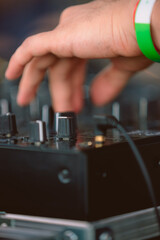DJ hand adjusting controls on professional mixer