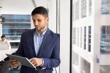 Fototapeta premium Serious successful Caucasian business executive man using online service