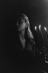 A mysterious woman stands in silhouette against a bright window, surrounded by dramatic smoke and shadows