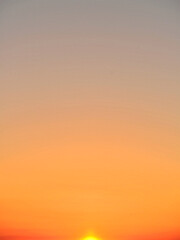 Sunset over the ocean. Colours ranging from orange-yellow to blue-grey.