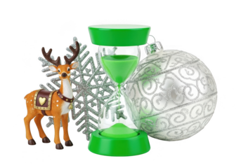 A festive christmas composition featuring a small reindeer figurine, a silver snowflake ornament, a green hourglass, and a large silver bauble isolated on transparent background