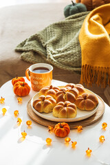 Autumn Table Setting with Pumpkin-Shaped buns with Cinnamon, Apples, Pumpkins, and Cozy Decor
