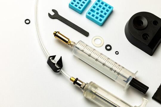 Hydraulic bicycle brake bleeding and oil change kit. Hydraulic brake service tools on a white background. Picture taken with flash light