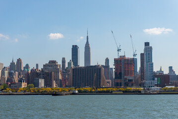 New York City, NY, USA. October 17, 2014: New York City skyline with the Empire State Building and construction cranes.