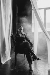 Confident woman in sheer black lace stands poised between white curtains, embodying strength, elegance, and modern gothic fashion