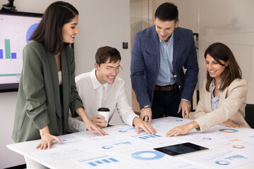 Fototapeta premium Team of happy young professional analysts working on marketing reports