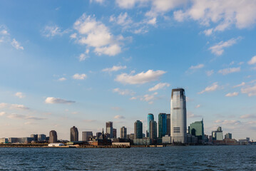 Naklejka premium New York City, NY, USA. October 17, 2014: Skyline of Jersey City with skyscrapers under a blue sky viewed from the Hudson River.